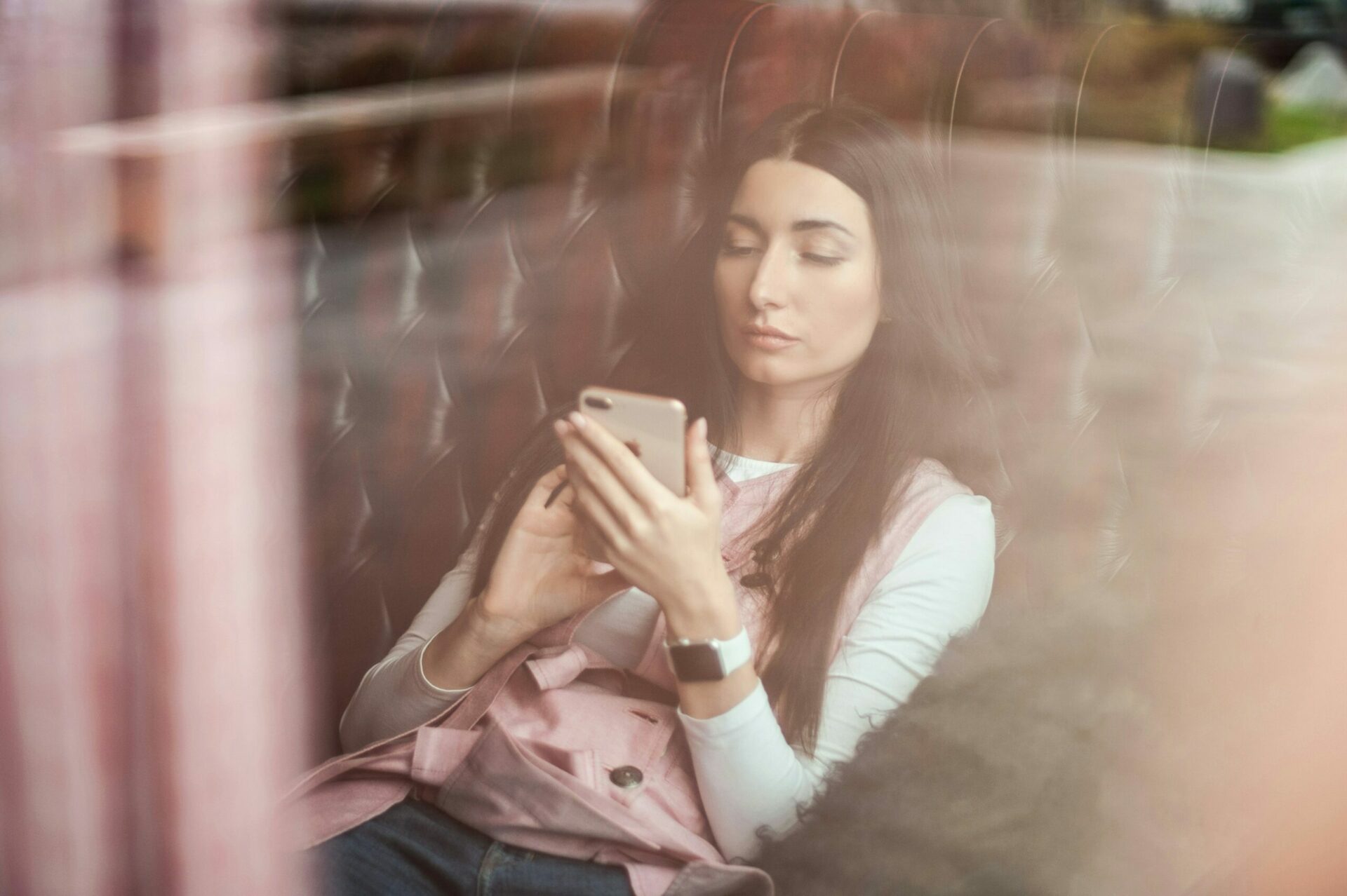 Femme regadant son portable dans un café